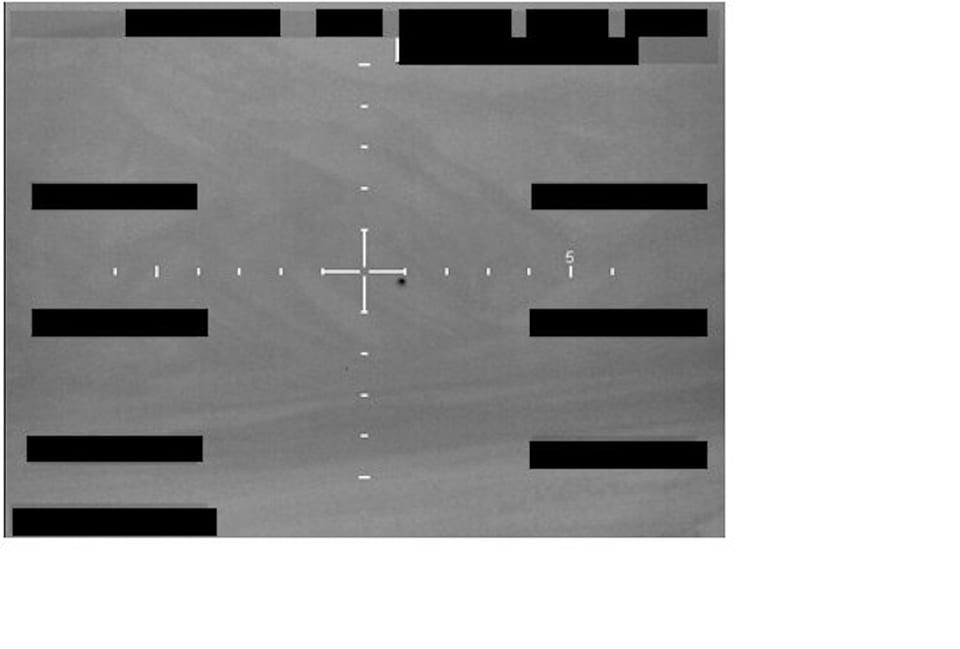 FBI Photo A001 from the 2026 UFO file image records, showing a grayscale sensor-style frame with redactions and a center reticle.